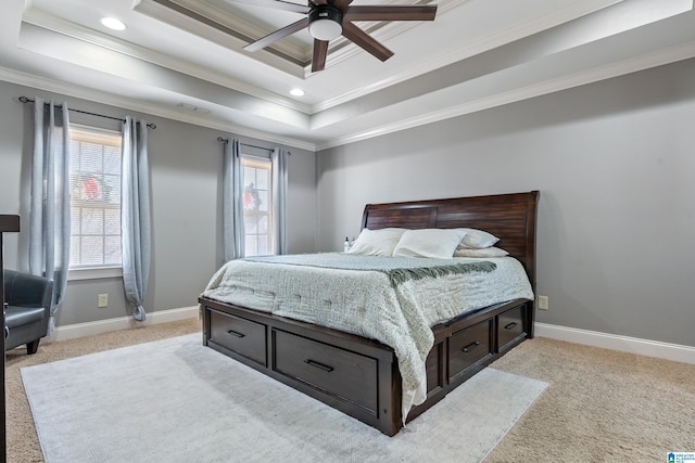 bedroom featuring light carpet, ceiling fan, ornamental molding, and a tray ceiling