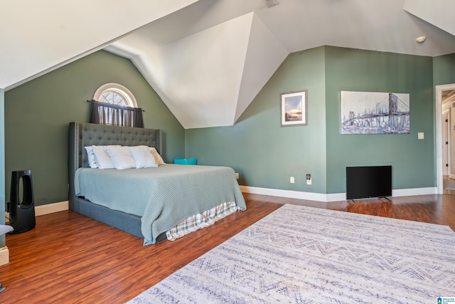 bedroom with dark hardwood / wood-style floors and lofted ceiling