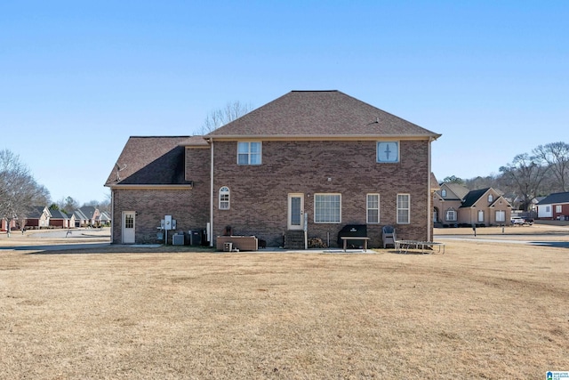 rear view of property with a yard and central air condition unit