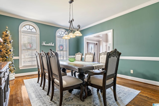 dining area with ornamental molding and hardwood / wood-style floors