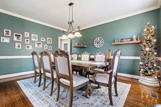 dining space with hardwood / wood-style floors and crown molding