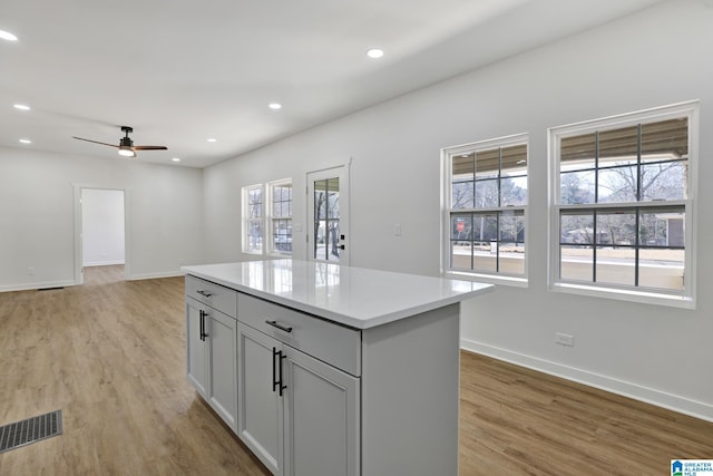 kitchen featuring plenty of natural light, light hardwood / wood-style floors, ceiling fan, and a kitchen island