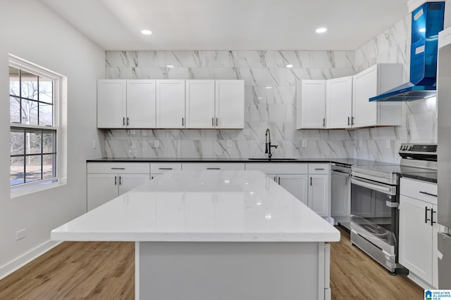 kitchen featuring white cabinetry, appliances with stainless steel finishes, sink, and wall chimney exhaust hood