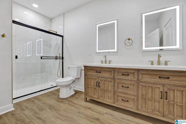 bathroom featuring hardwood / wood-style flooring, toilet, vanity, and walk in shower