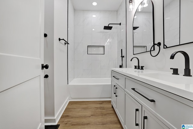 bathroom with tiled shower / bath, wood-type flooring, and vanity