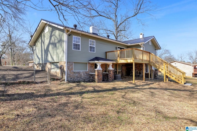 rear view of property featuring a wooden deck, central AC unit, and a lawn