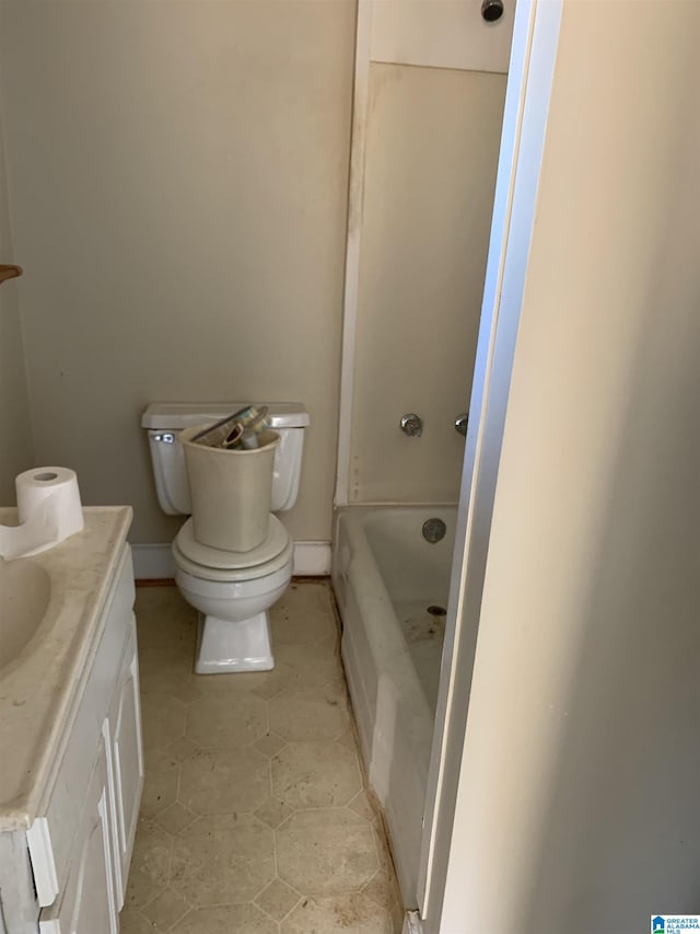 bathroom featuring vanity, toilet, and baseboards