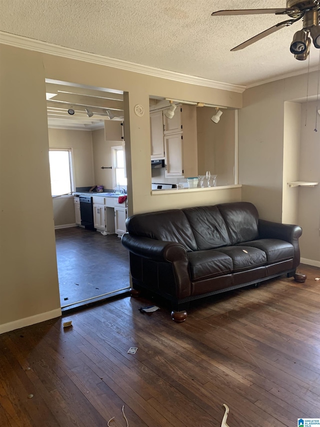 living room with ornamental molding, dark wood finished floors, baseboards, and a ceiling fan