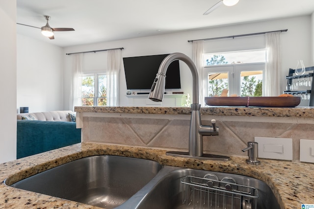 interior details with ceiling fan, sink, and stone counters