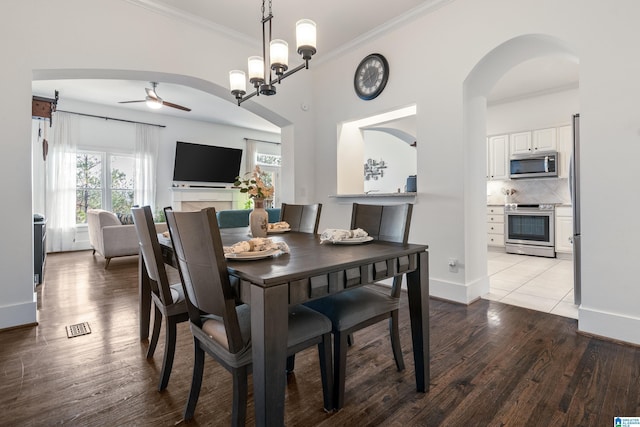 dining room featuring crown molding, ceiling fan with notable chandelier, and light hardwood / wood-style flooring