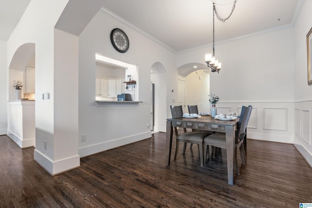 dining space featuring dark hardwood / wood-style floors, ornamental molding, and an inviting chandelier