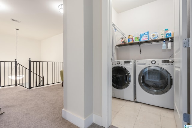 clothes washing area featuring light carpet and independent washer and dryer