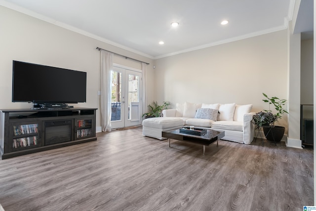 living room featuring wood-type flooring, ornamental molding, and french doors