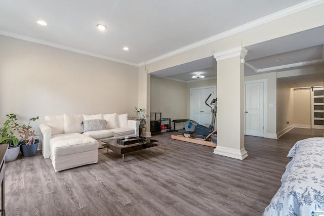 living room featuring a barn door, decorative columns, ornamental molding, and hardwood / wood-style floors