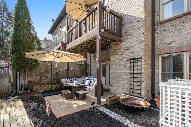 view of patio / terrace featuring a balcony and an outdoor living space with a fire pit