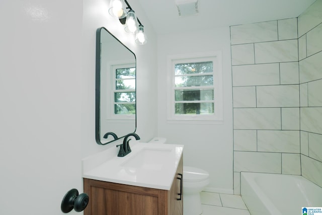 full bathroom with toilet, tiled shower / bath, tile patterned floors, and vanity