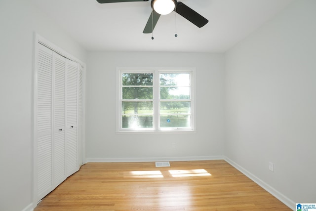 unfurnished bedroom featuring ceiling fan, a closet, and light hardwood / wood-style flooring