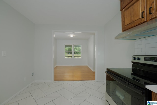 kitchen with electric range oven and light tile patterned floors