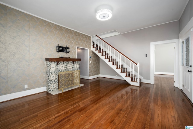 unfurnished living room featuring a fireplace, ornamental molding, and hardwood / wood-style floors