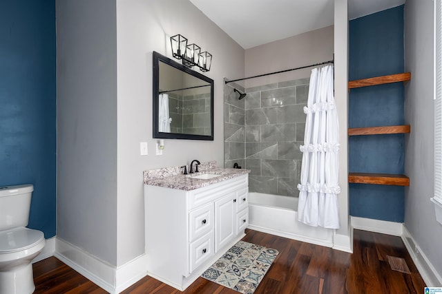 full bathroom with hardwood / wood-style floors, toilet, vanity, and shower / tub combo