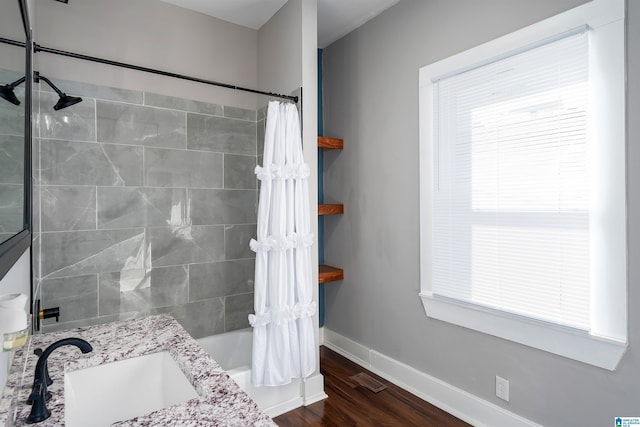 bathroom with shower / tub combo, hardwood / wood-style floors, and vanity