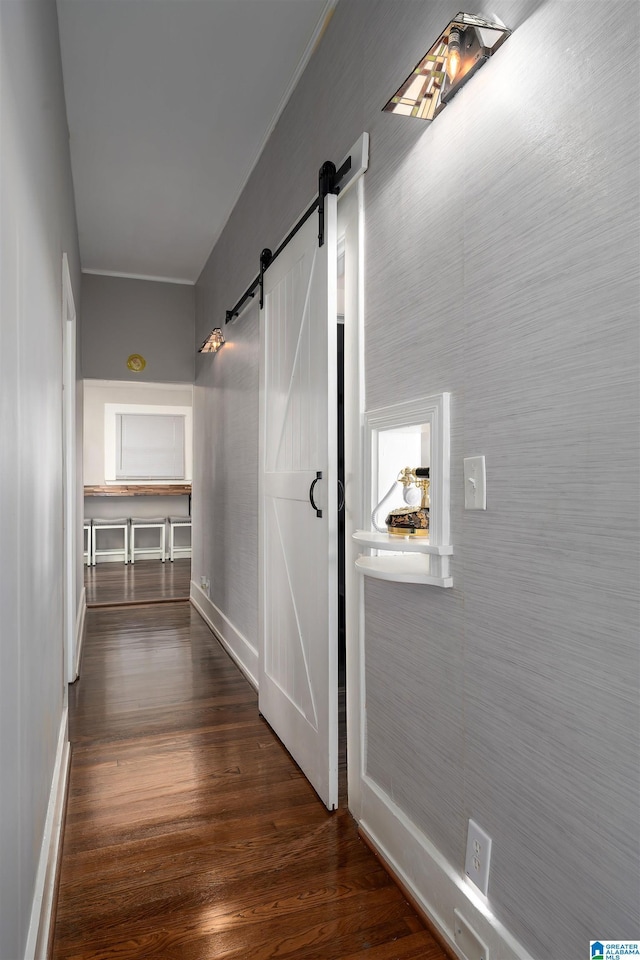 hallway with a barn door and dark hardwood / wood-style floors