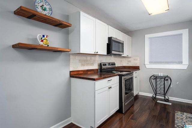 kitchen with appliances with stainless steel finishes, dark hardwood / wood-style flooring, white cabinets, and tasteful backsplash