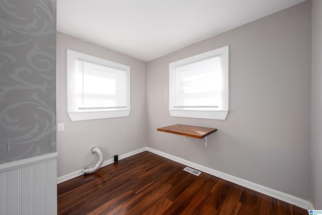 clothes washing area featuring dark hardwood / wood-style floors and plenty of natural light