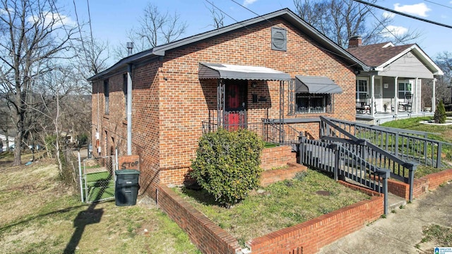 bungalow featuring covered porch and a front yard