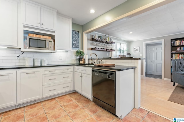 kitchen with sink, white cabinetry, black dishwasher, and kitchen peninsula