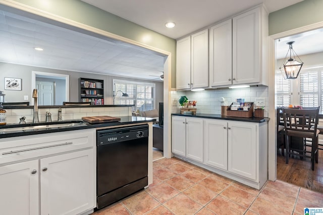 kitchen with ceiling fan with notable chandelier, dishwasher, white cabinetry, sink, and backsplash