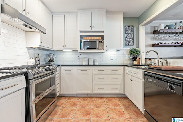 kitchen featuring appliances with stainless steel finishes, sink, white cabinets, tasteful backsplash, and light tile patterned flooring