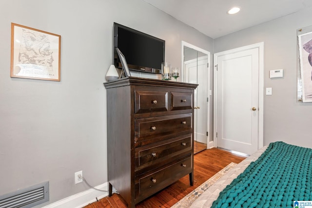 bedroom with hardwood / wood-style flooring and a closet