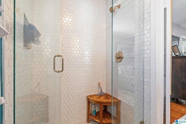 bathroom with walk in shower and hardwood / wood-style floors