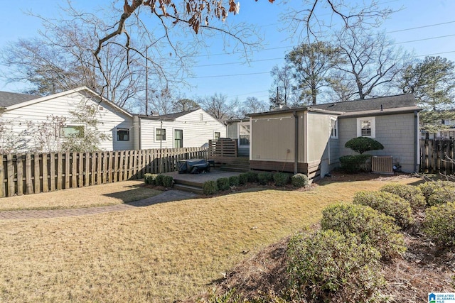 exterior space featuring a wooden deck, central AC unit, and a lawn