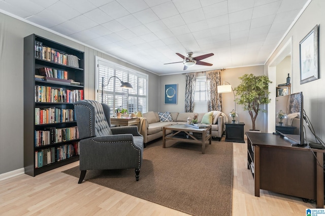 living room with ceiling fan, crown molding, and light hardwood / wood-style floors