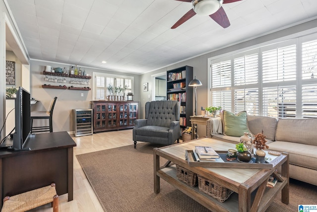 living room with wine cooler, ornamental molding, and light hardwood / wood-style floors