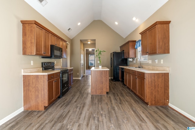 kitchen featuring lofted ceiling, sink, dark hardwood / wood-style flooring, a center island, and black appliances