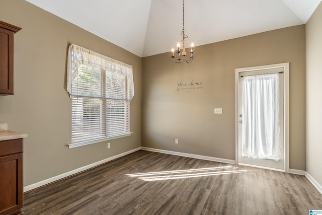 unfurnished dining area with dark wood-type flooring, lofted ceiling, and a chandelier