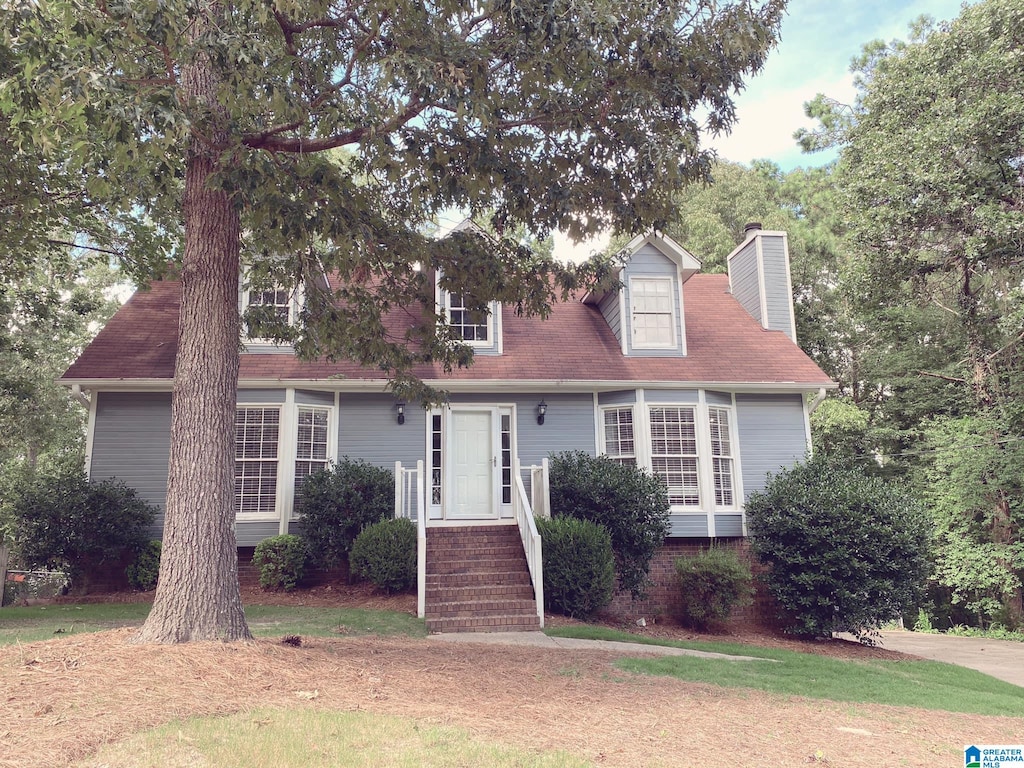 cape cod house with a front yard