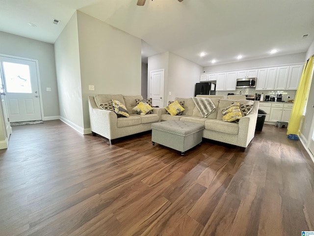 living room featuring ceiling fan and dark hardwood / wood-style floors