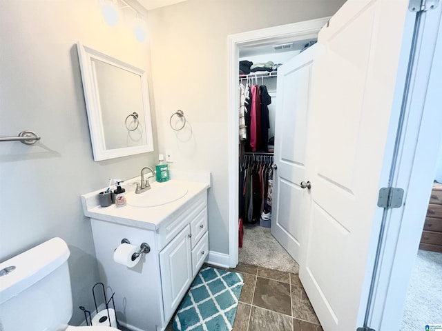 bathroom featuring toilet, vanity, and tile patterned flooring