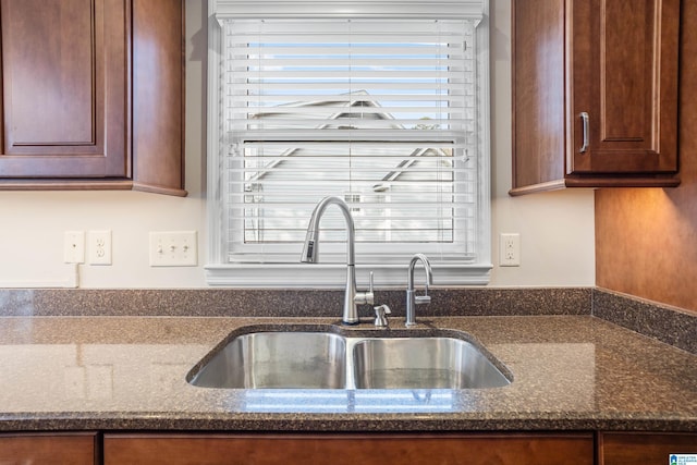 kitchen with dark stone countertops and a sink