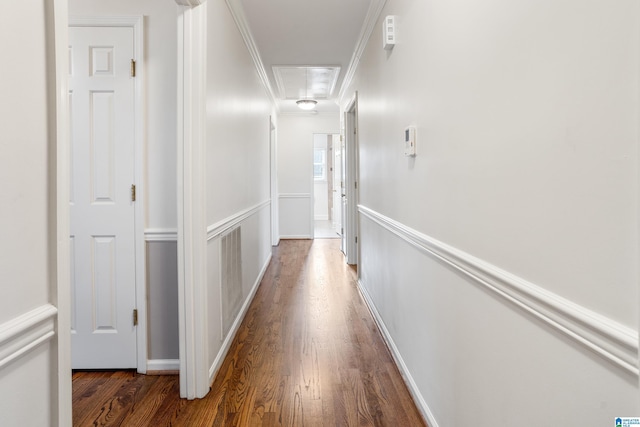 hallway with attic access, ornamental molding, dark wood finished floors, and baseboards