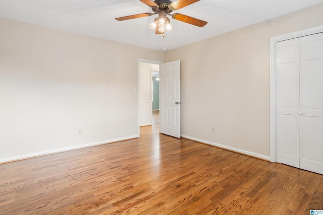 unfurnished bedroom with a closet, light wood-style flooring, and baseboards