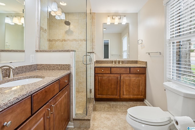 bathroom with a stall shower, tile patterned flooring, two vanities, and a sink