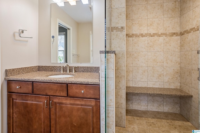 full bath featuring a tile shower and vanity