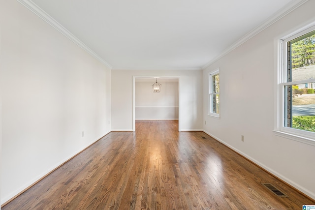 unfurnished room with crown molding, dark wood-style flooring, visible vents, and plenty of natural light