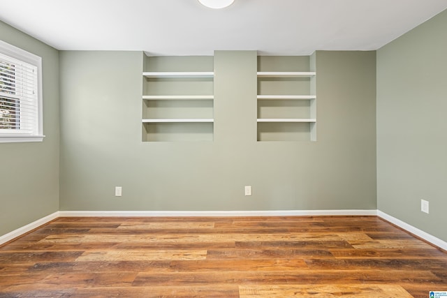 unfurnished room with baseboards and wood finished floors