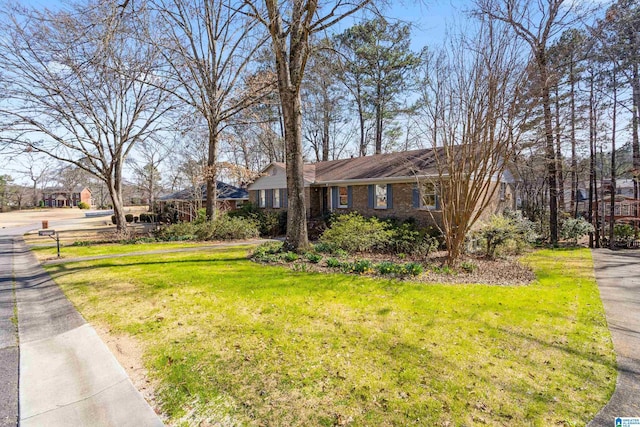 single story home featuring brick siding and a front yard